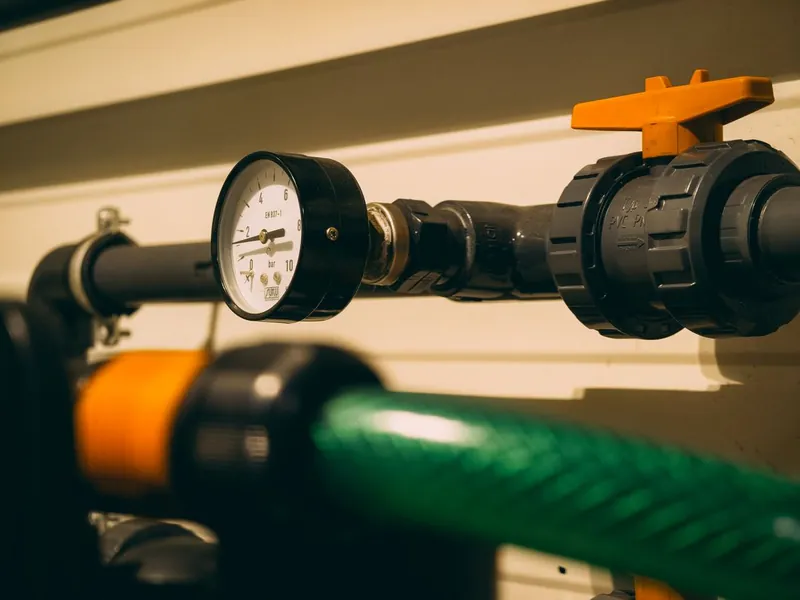 Pressure gauge and valves on pool filter plumbing checked during filter cleaning